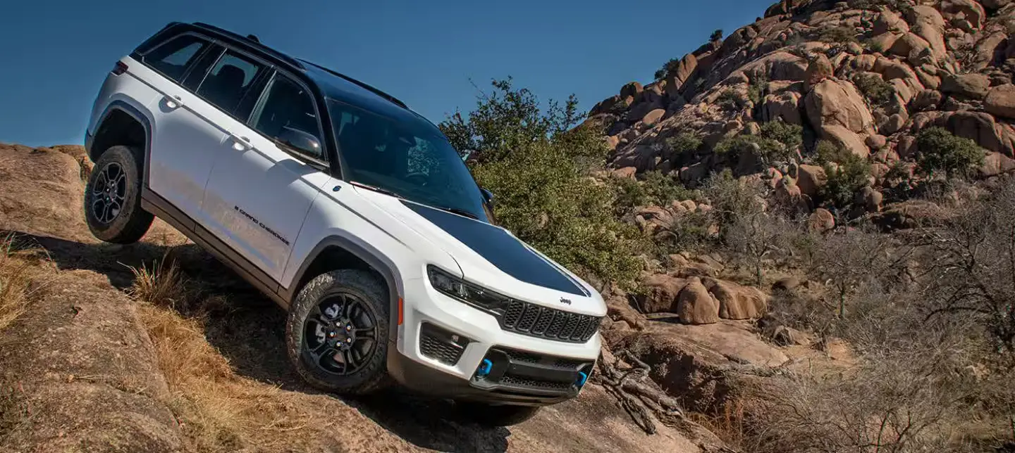 white jeep cherokee driving down a rocky terrain