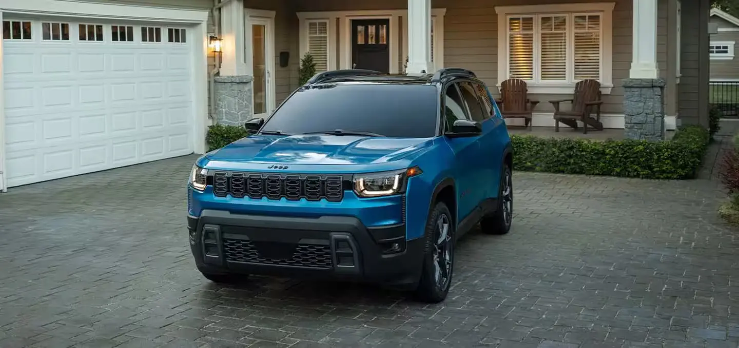blue jeep cherokee parked outside of house