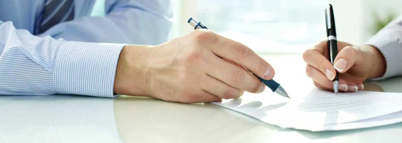 two people signing financing paperwork