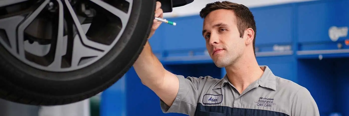 Hyundai mechanic inspecting a wheel