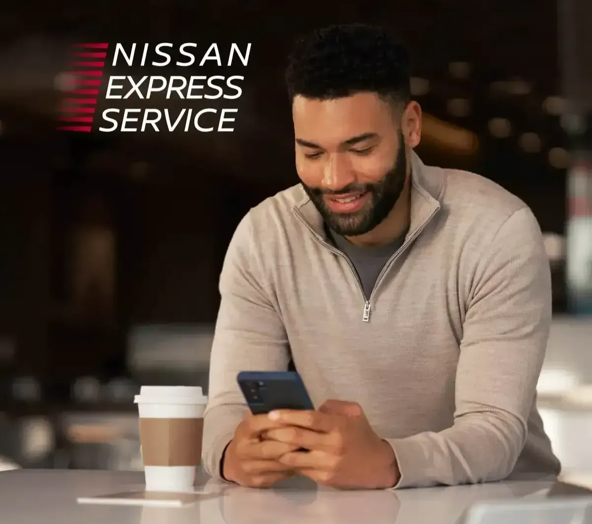 Customer using a phone while waiting for Nissan Express Service
