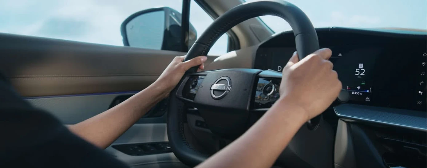 Driver holding the steering wheel inside a Nissan Murano