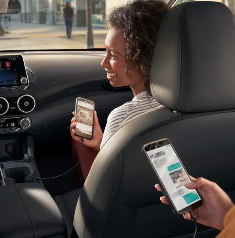 Passengers using smartphones inside a Nissan vehicle