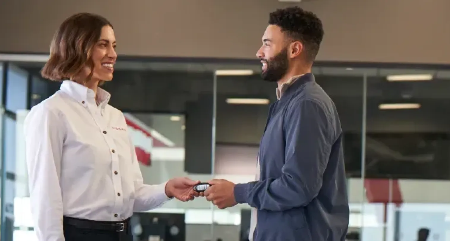 Nissan team member handing keys to a customer at the dealership