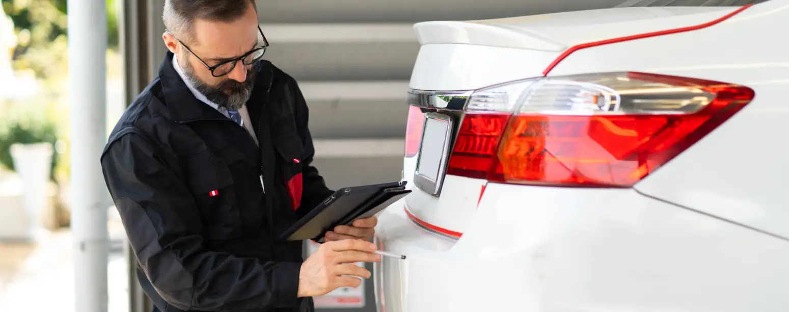 Technician reviewing vehicle details for branded title information at America’s Xtreme Auto