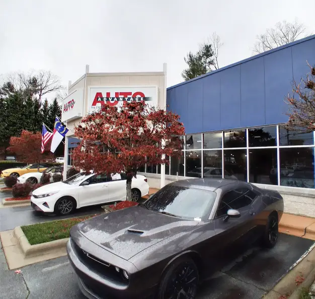Exterior of Auto Advantage dealership with vehicles in front.