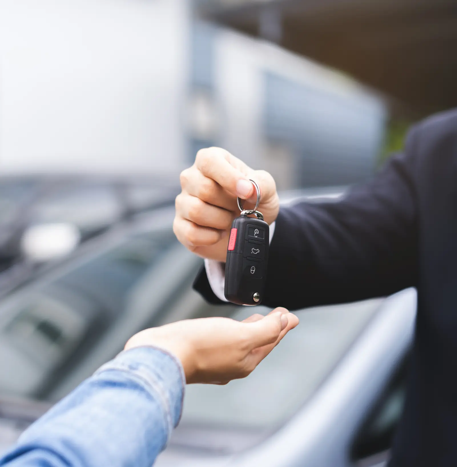 Car keys being handed to customer at dealership.