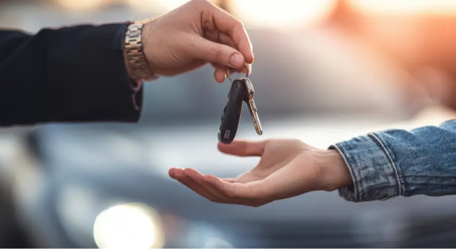 Auto Sense North salesperson handing over car keys to a customer after bad credit loan approval