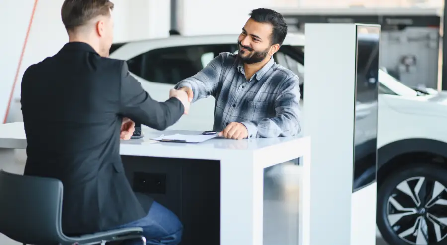 Salesperson shaking hands with a customer at Auto Sense North's Finance Department near Concord, NH