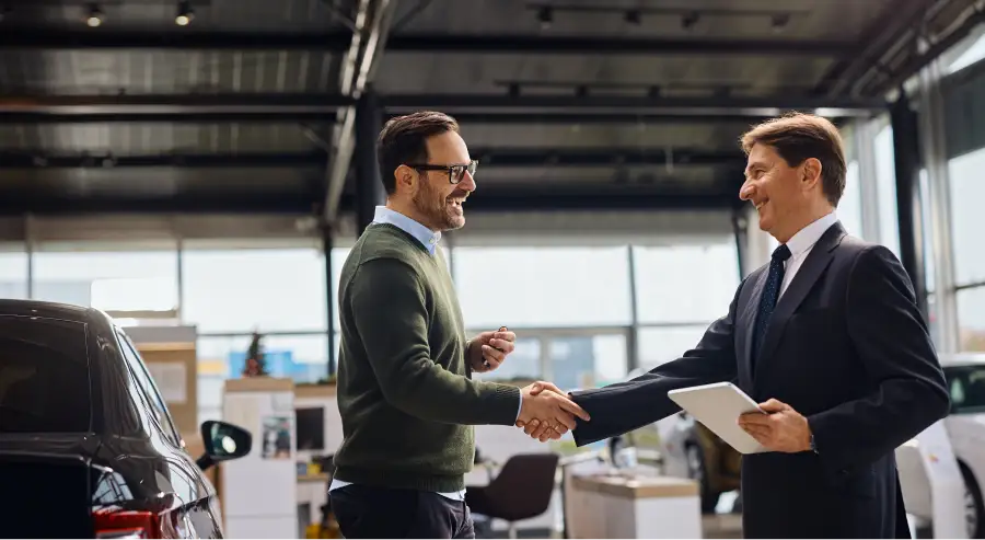 Salesperson shaking hands with a customer at Auto Sense North's Finance Department near Concord, NH