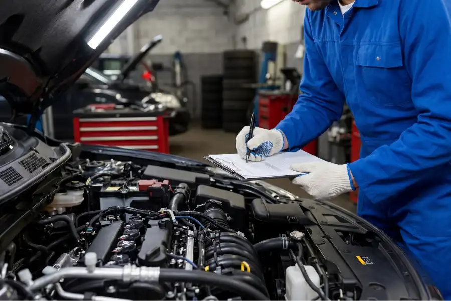 Technician performing a vehicle inspection at Auto Sense North in Chichester, NH