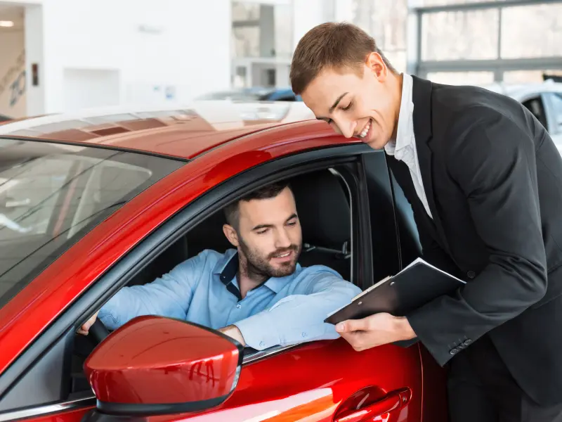 Salesperson handing over a vehicle history report with keys