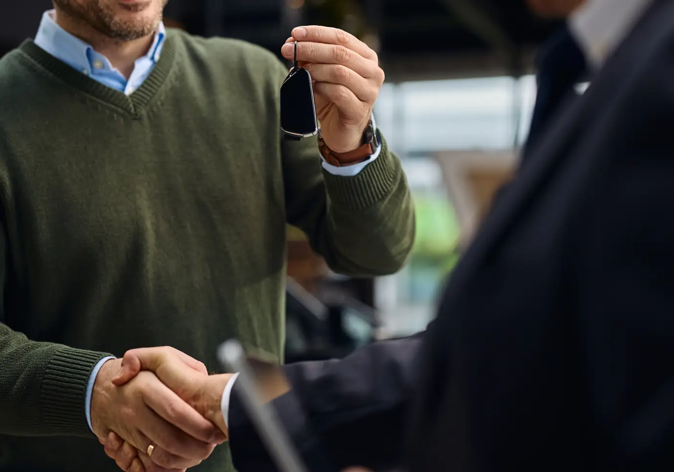 Customer receiving car keys from a dealership representative at Cars614.