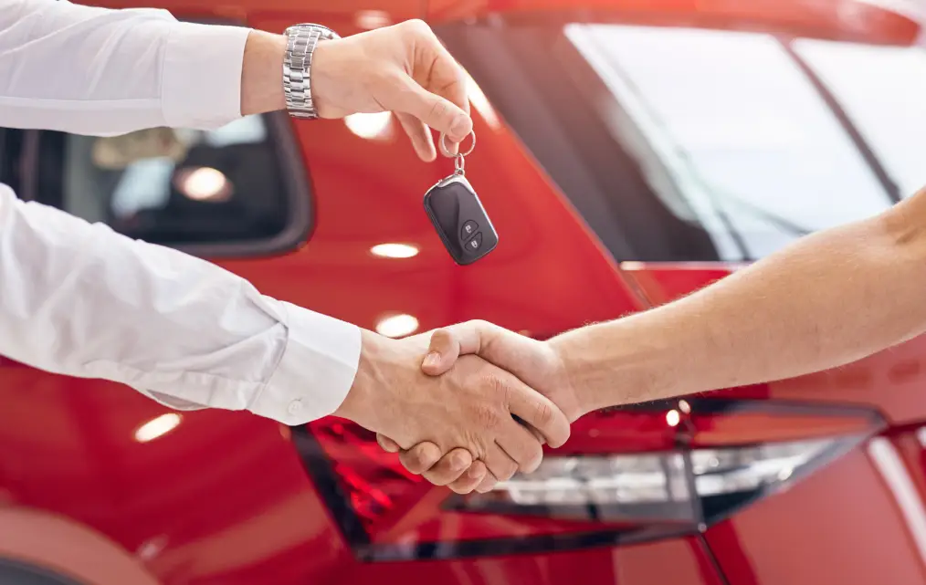 Vehicle key handoff during a car sale at Autos of Chicago