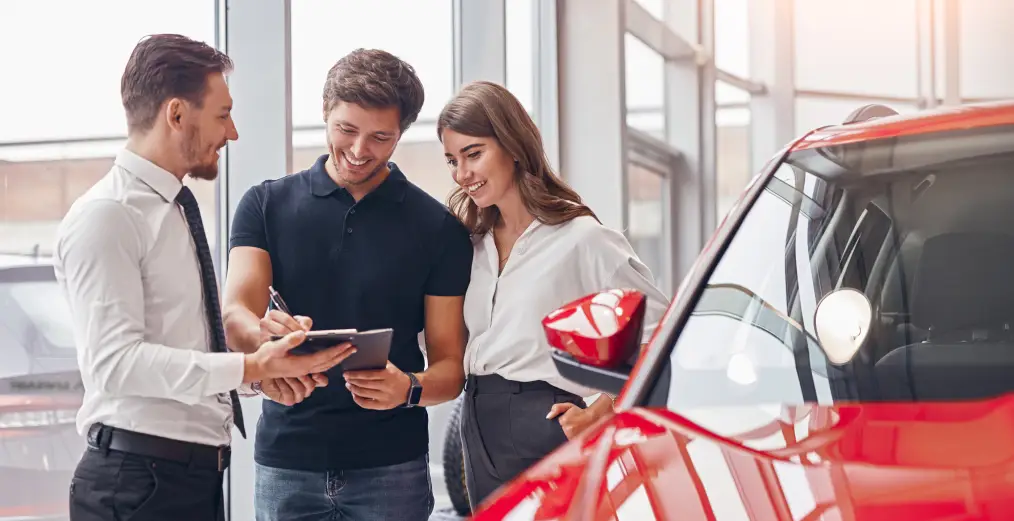 Autos of Chicago sales consultant helping customers review vehicle details in the showroom