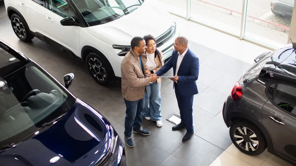 Customers discussing auto financing options with a dealership consultant