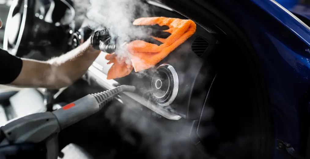 Vehicle interior being steam cleaned during a professional detailing service