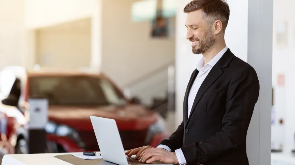 Customer browsing vehicles online from a laptop at a dealership