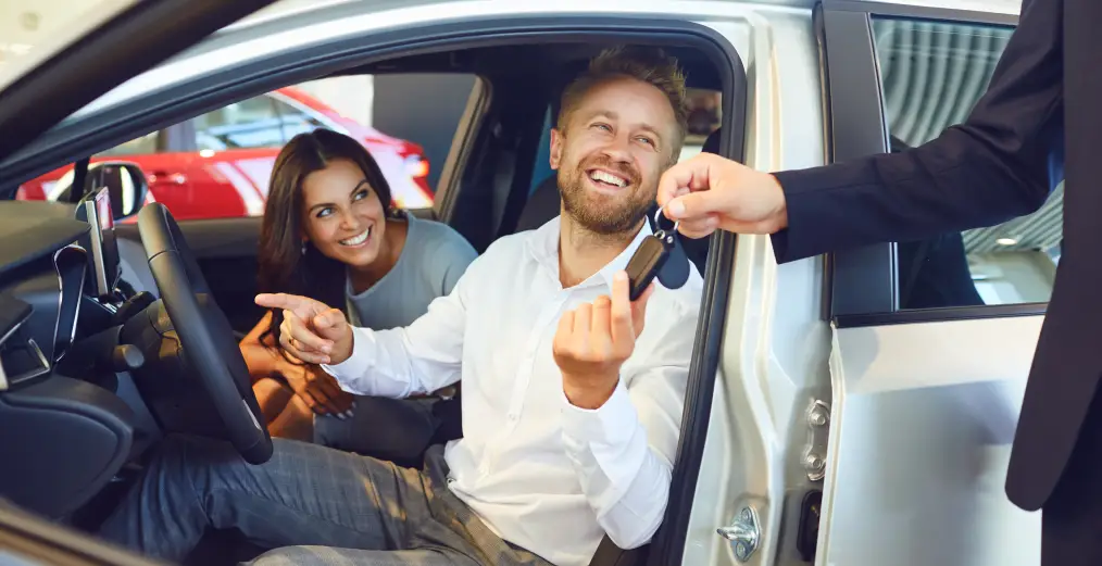 Happy customers receiving keys after buying a vehicle at Autos of Chicago