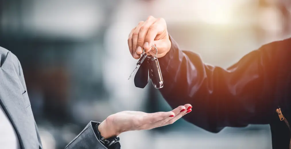 Car keys being handed to a customer during the trade-in or selling process