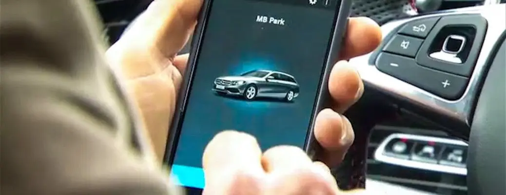 A man using the Mercedes remote parking pilot app.