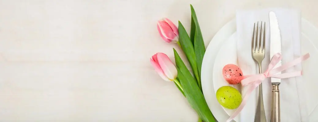 Easter table setting with pink tulips on white wooden background