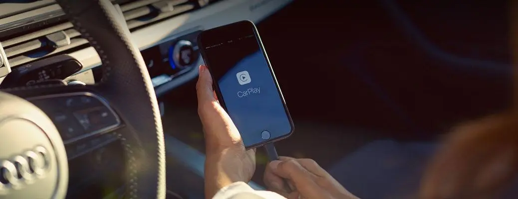 A woman learning how to use Apple CarPlay in her Audi.