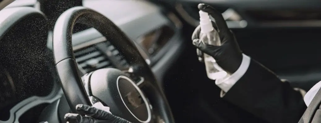 A man disinfecting the interior of a car.