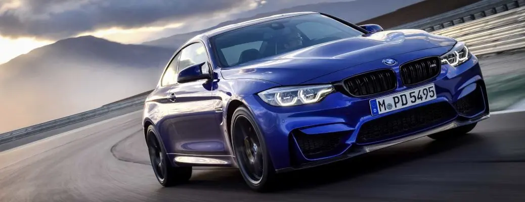 BMW M4 CS racing on a track.