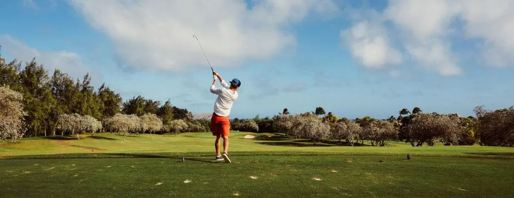 A golfer taking a swing on a golf course.