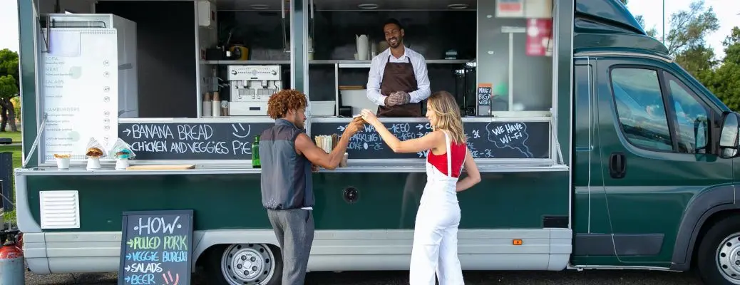 Two people buying food at a food truck near Dallas at lunchtime.