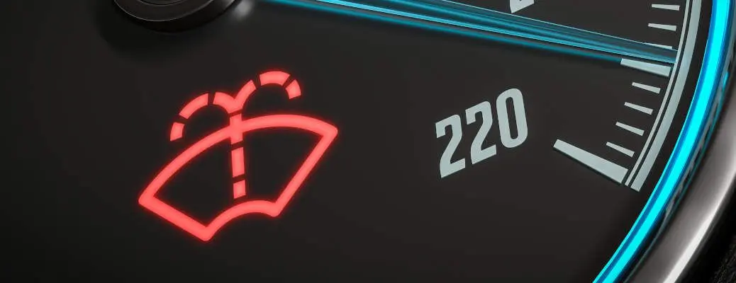 Low windshield washer fluid indicator warning in car dashboard.