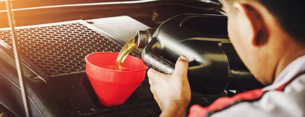 A man changing the oil in a Mercedes.
