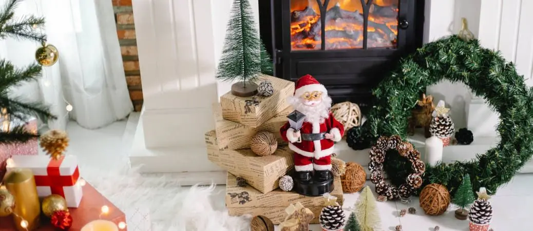 Christmas decorations by a fireplace.