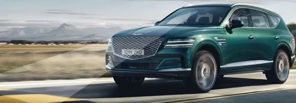 Green 2021 Genesis GV80 with Advanced Safety Systems on Desert Highway