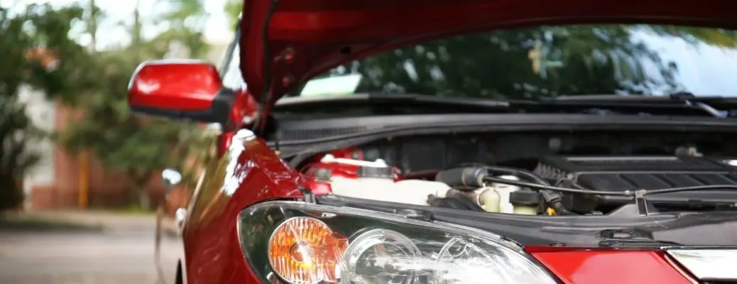 A car with the hood open getting a winter service.