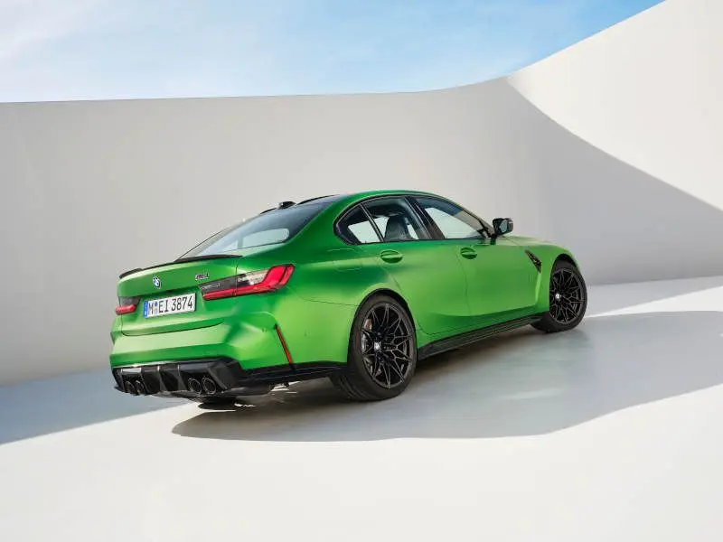 A rear quarter view of the 2025 BMW M3 in metallic green.