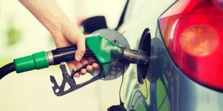 Hand with a pump refueling a car
