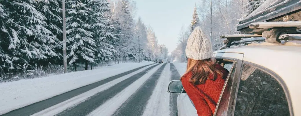 Magic car trip on the road by winter forest covered by snow