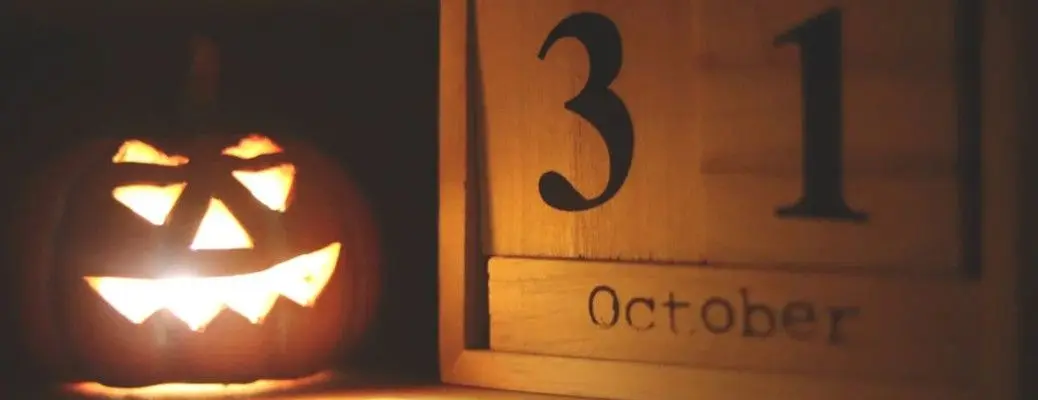 A Jack o' Lantern next to a calendar marking the date for Halloween 2023 in Dallas, where there are many things to do.