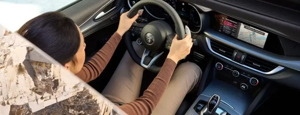 A woman experiencing the performance in an Alfa Romeo Stelvio behind the steering wheel.