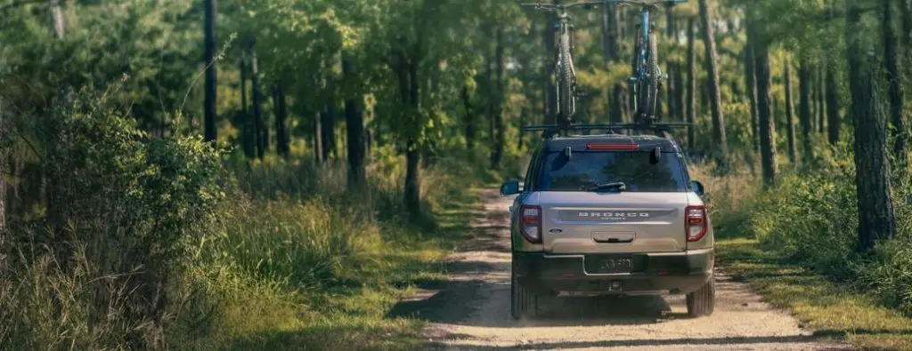 A rear shot of the Ford Explorer on a forested dirt road.