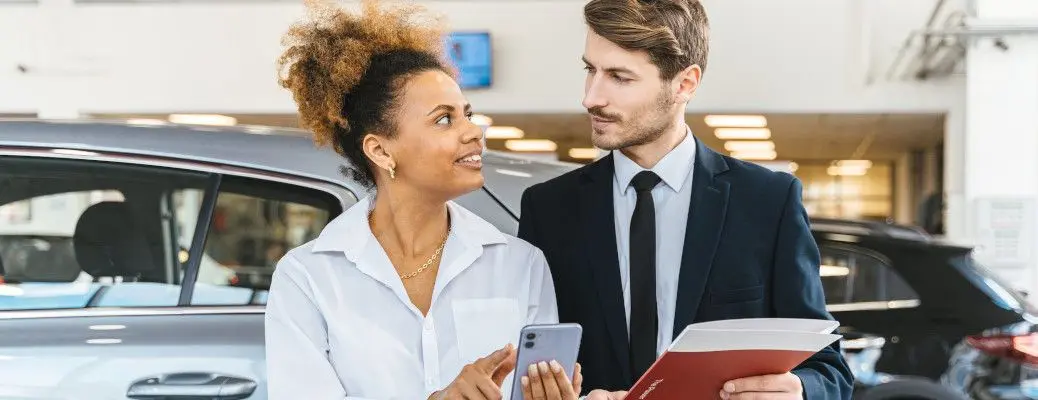 Customer and salesperson on a car lot.
