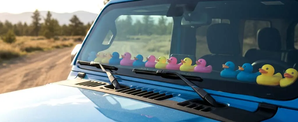Blue Jeep with colorful duckies on the dash