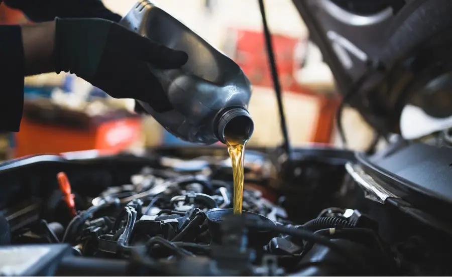 Technician pouring fresh motor oil into a vehicle engine at BLVD Auto Inc