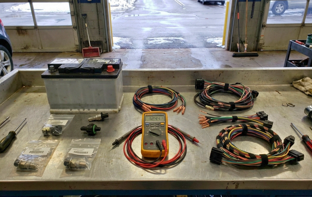 A flat-lay knolling arrangement of automotive electrical components