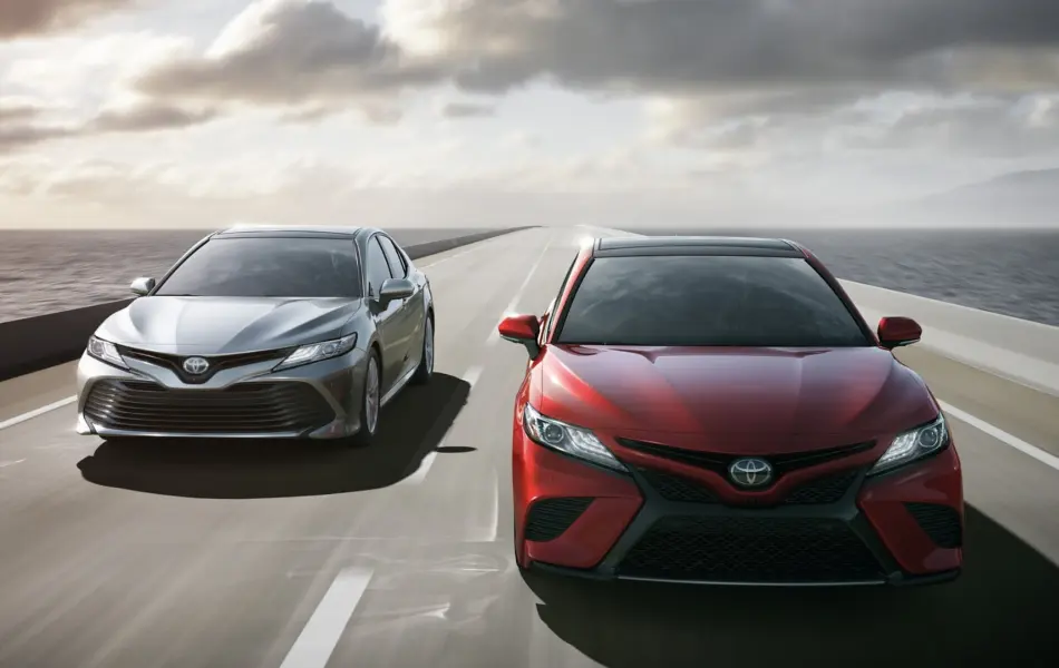 Red and silver Toyota Camry on road
