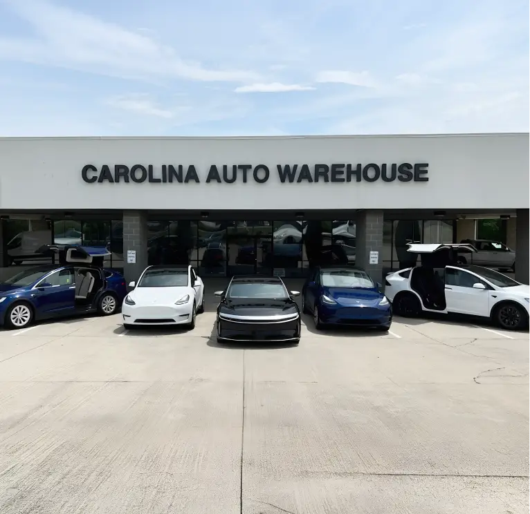 Front view of Carolina Auto Warehouse dealership with vehicles displayed outside the showroom
