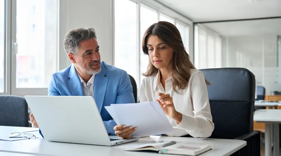Two people overlooking finance documents