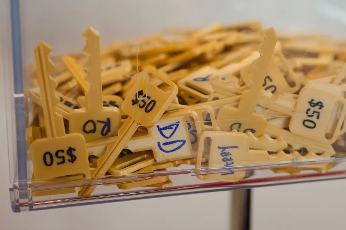 Golden 50 dollar keys with donor initials filling the Drive for a Cure key box supporting childhood cancer at Certified AutoBrokers in Grand Island NY
